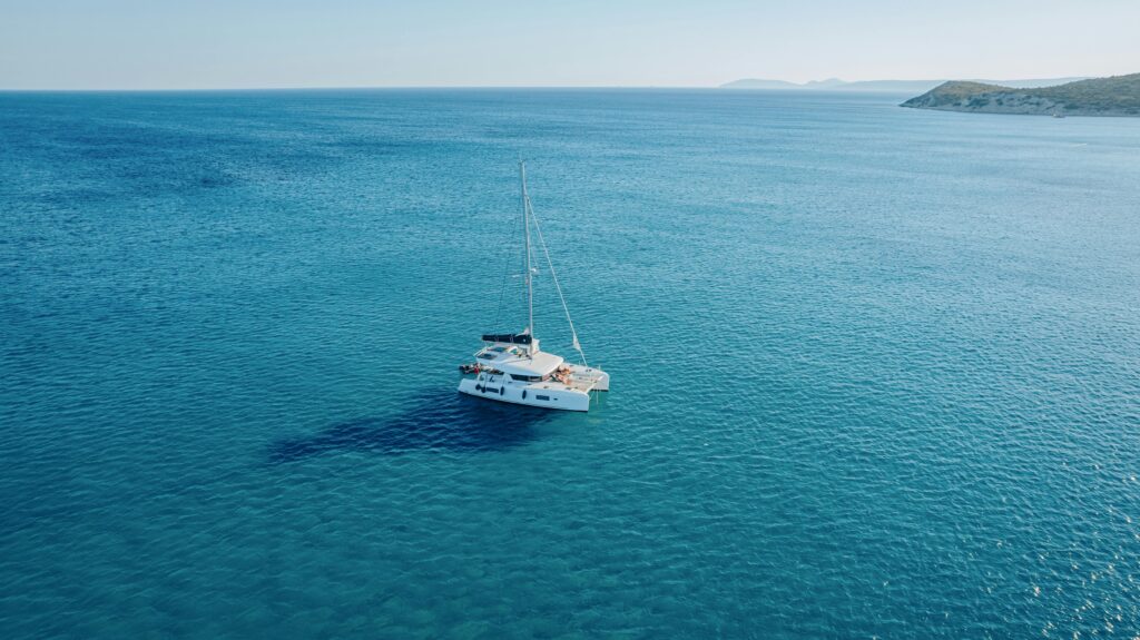 A peaceful image of a yacht sailing on the calm, blue waters near Alaçatı, Türkiye.